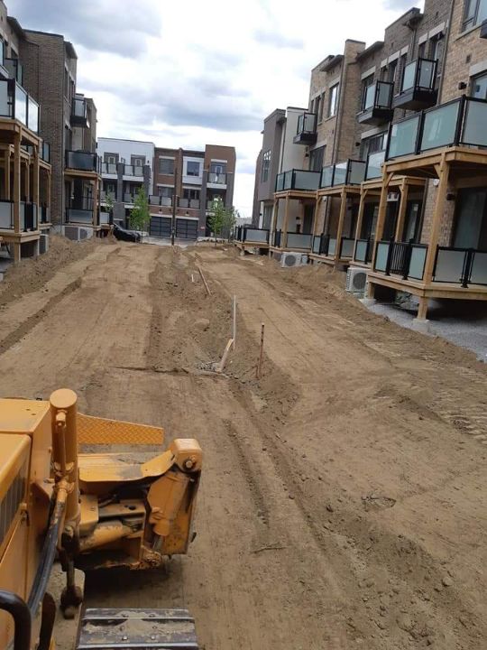 Excavation equipment grading a multi-home construction site