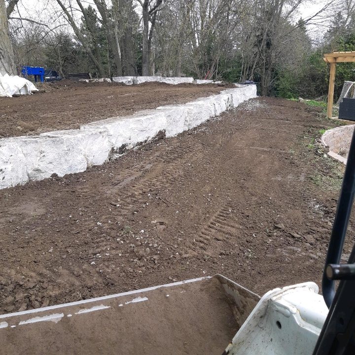 Backyard graded beside a new stone retaining wall