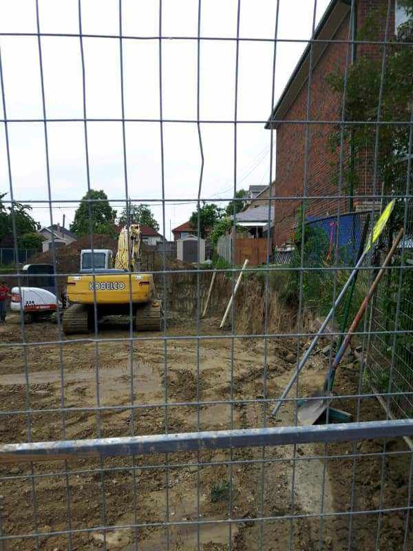 Excavator on a secured residential demolition site