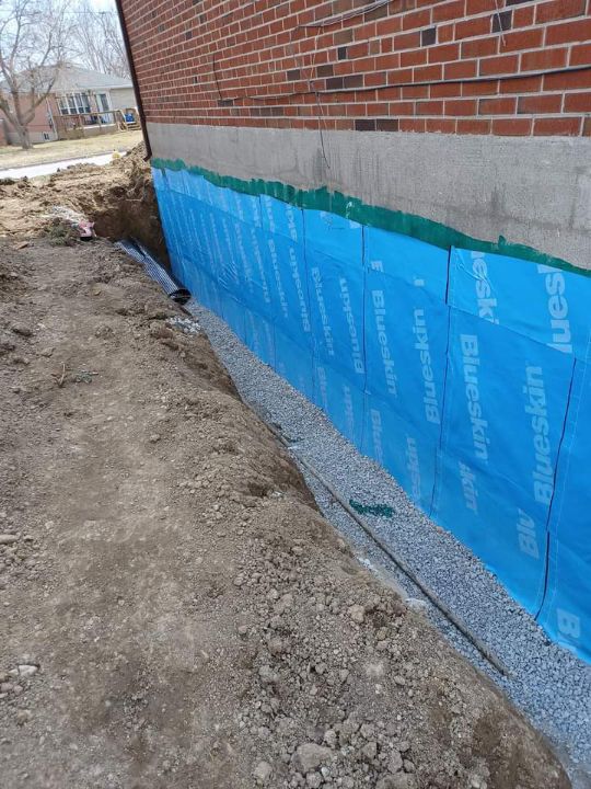 Completed exterior foundation waterproofing before backfilling