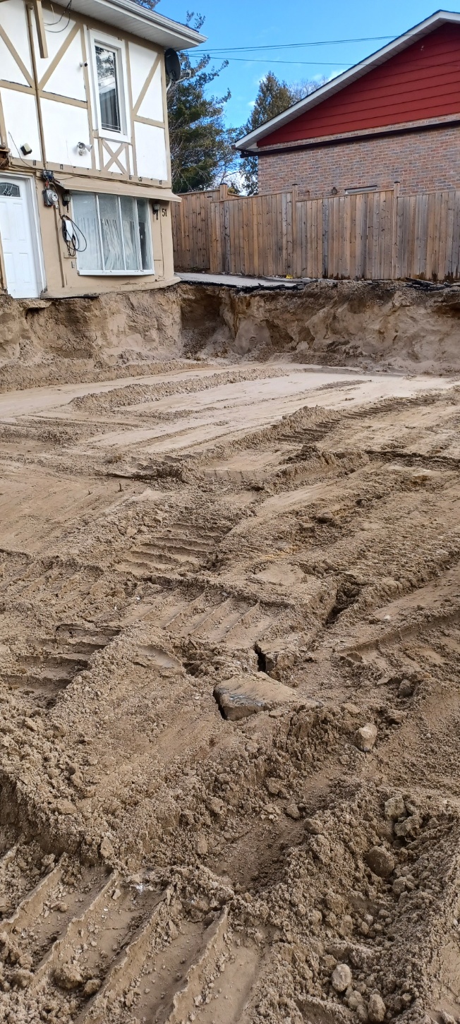 Large residential swimming pool excavation beside a home