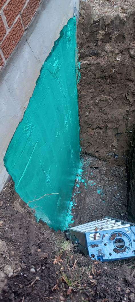 Waterproof coating applied to an exterior foundation wall