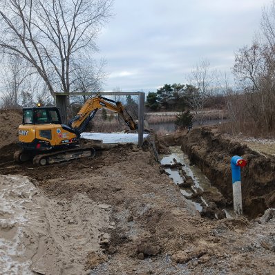 Compact excavator completing trench and site work