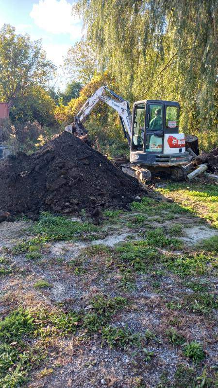 Excavator moving fill material for a swimming pool fill-in
