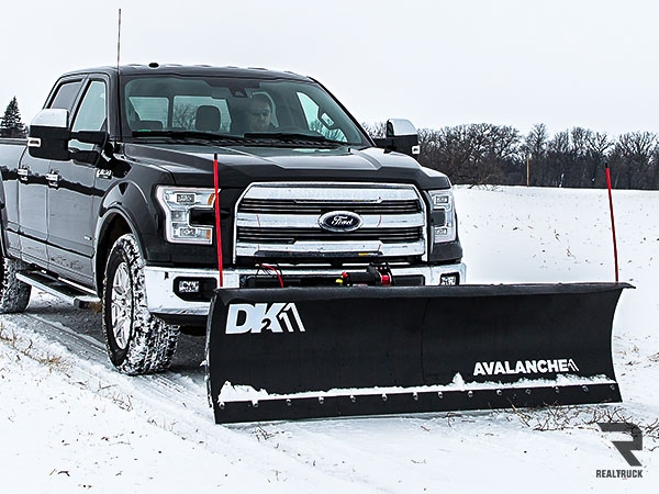 Pickup truck equipped with a wide snowplow blade